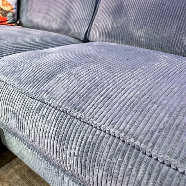 Ecksofa, zwei Sitzflächen, zwei große Rückenkissen, breite Armlehnen, Naht außen, Cord, tiefe schwarze Füße